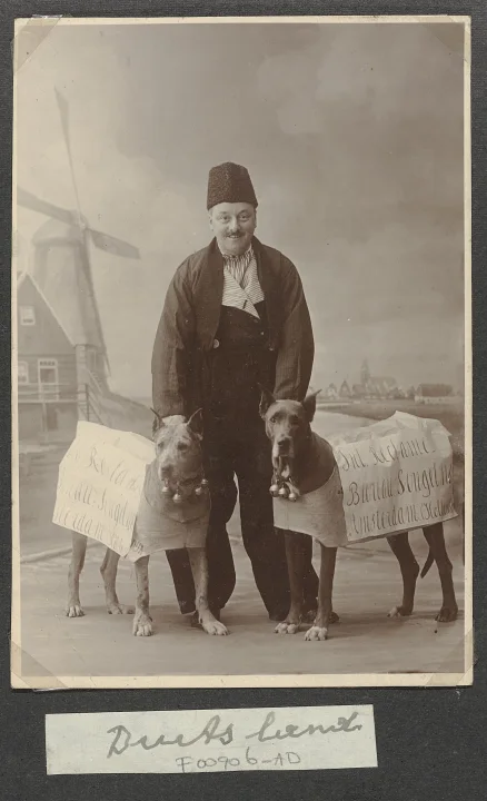 Two dogs beside a person in a framed monochrome photograph · Dog photo — Pictures of Dog
